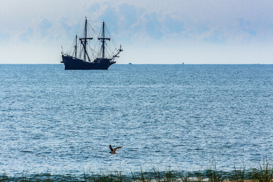 Ancient replica pirate ship in the Atlantic Ocean just after sunrise