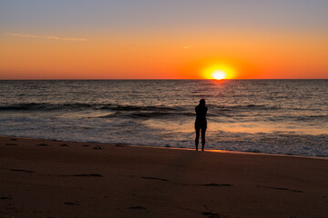 Lone Woman watching the Bethany Beach Sunrise over the Atlantic Ocean