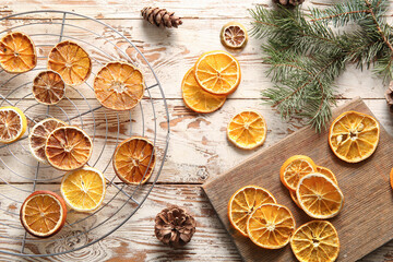 Stand and board with dried orange slices on white wooden background