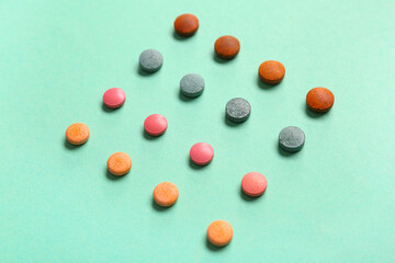 Square made of different pills on color background