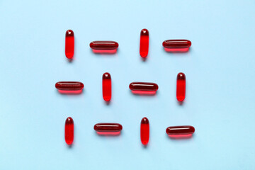 Composition with red capsules on color background
