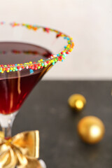 Glass of tasty red margarita with decor on color background