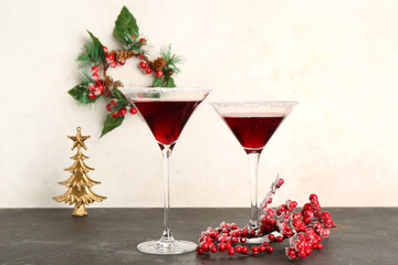 Glasses of tasty red margarita with berries on black table against white grunge background