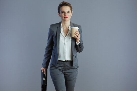 pensive 40 years old business owner woman walking against gray