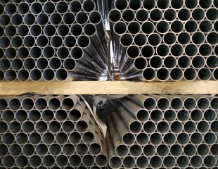 tubos de metal acopiados en una nave industrial
