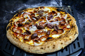 Calabrian sausage pizza served on a round board and set table