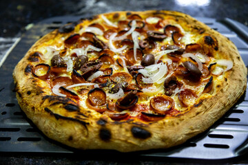 Calabrian sausage pizza served on a round board and set table