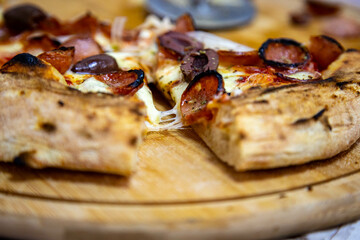 Calabrian sausage pizza served on a round board and set table