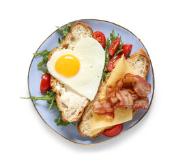 Plate with tasty fried egg, cut croissant, tomatoes and arugula on white background