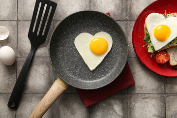 Composition with tasty fried eggs and toasts on grey tile background
