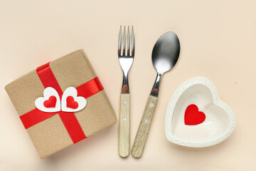Beautiful table setting with gift box on beige background. Valentine's Day celebration