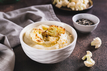 Homemade creamy cauliflower soup in a bowl on the table