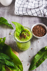 Detox smoothie made from green sorrel and flax seeds in a glass on the table vertical view