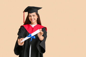 Happy female graduating student with diploma on beige background
