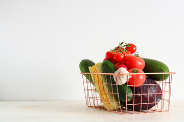 Basket with different fresh vegetables on white background