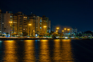 noite em Florianópolis e as luzes refletindo no mar e os prédios da avenida beira mar norte da...