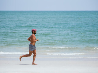 Man Running Barefoot on a Tropical Beach