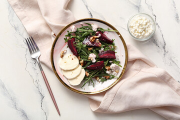 Plate of fresh salad with beet, mozzarella and cottage cheese on white background