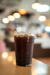 Close-up of Americano ice coffee or black coffee in cup mug on  wood desk office desk in coffee shop at the cafe in garden,during business work concept