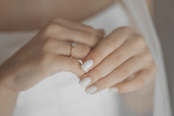 A woman is holding her hand up to show off her ring