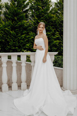 Fototapeta premium A woman in a white wedding dress stands on a balcony