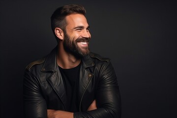 Fototapeta premium Portrait of a handsome smiling man in a leather jacket on a dark background