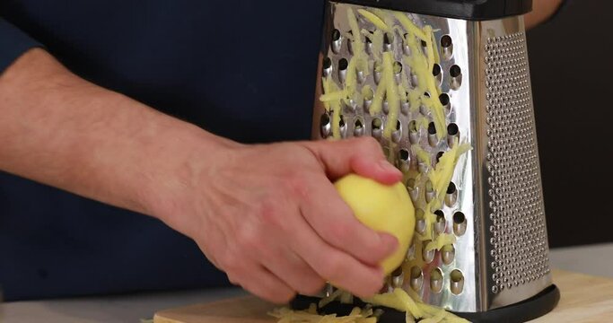 A man grates raw potatoes on a grater, showing step-by-step instructions 