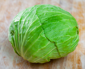 Obraz premium Ripe fresh cabbage and knife on cutting board