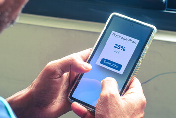 Person's smartphone displaying package plan offer with discount rate for products or service. Discounted package deals benefits concept.