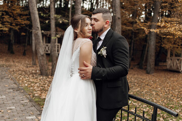 Naklejka premium A bride and groom are hugging each other in a forest