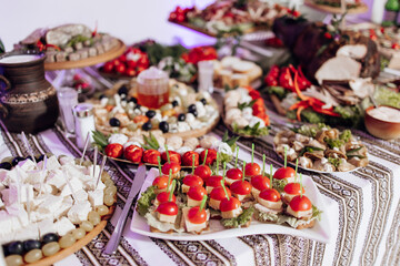 A table is covered with a variety of food, including sandwiches, salads