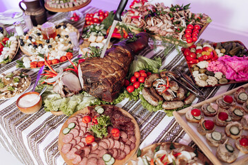 A table is covered with a variety of food, including meats, vegetables