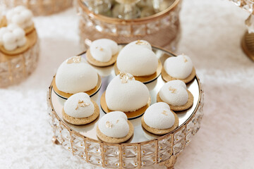A tray of white pastries with gold accents