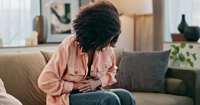 Sofa, home and woman with pain in stomach for menstruation, cramps and constipation bloating. House, female person and abdomen with tummy ache for ibs issue, indigestion problem and diarrhea of virus