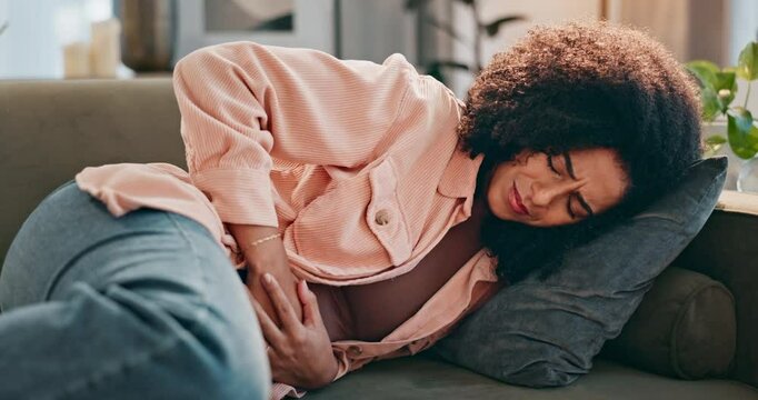 Living room, sofa and woman stomach in pain for diarrhea, menstruation and constipation in virus. Female person, home and abdomen with tummy ache for ibs cramps, digestion issue and gastro problem
