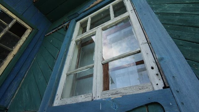 Window in an abandoned wooden house in the village. Broken window