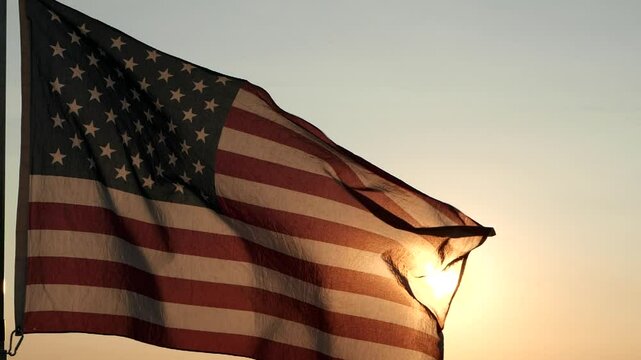 Celebrate 4th of July, Independence Day, Veteran's Day, Holiday, Celebration. In backdrop,  stunning sunset is accompanied by waving of American flag. Concept Independence Day, Freedom, Fourth of July