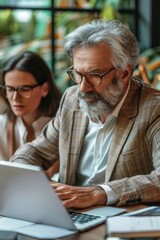 Obraz premium Man and woman collaborating on computer, great for team or work-from-home concepts
