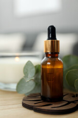 Aromatherapy. Bottle of essential oil and eucalyptus leaves on wooden table