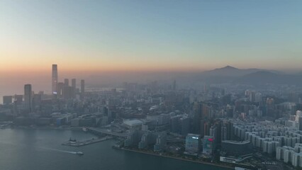 Aerial view of Hong Kong's stunning skyline and harbor, capturing the city's iconic skyscrapers, serene waters, and breathtaking sunset over Victoria Harbour