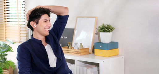 Young happy man relaxing and smiling while working at home office