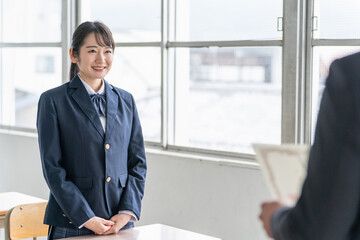 卒業式に卒業証書・賞状を渡す先生と受け取る生徒（女子高生・高校生・中学生）
