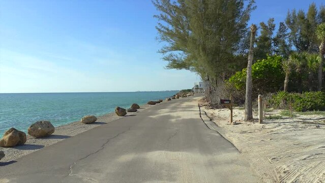Casey Key coastal residential community picturesque street. Car point of view driving on scenic road in sunny Florida.