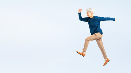 ジャンプするシニア女性の全身写真（切り抜き背景透過PNGも販売しております。作成者リンクから「PNG」で検索してください）