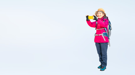 スマホで撮影する登山服を着たシニア女性の全身写真（切り抜き背景透過PNGも販売しております。作成者リンクから「PNG」で検索してください）