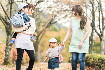 Fototapeta premium 秋の公園を散歩・遠足する保育士の女性と園児（保育園・幼稚園保母） 