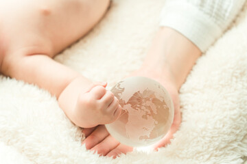 赤ちゃんと地球を持つ手元
