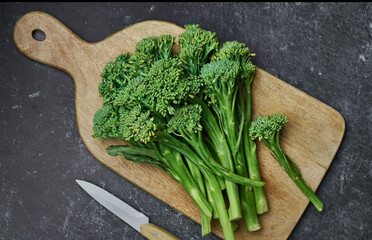 fresh broccolini on a kitchen cutting board, top view. 