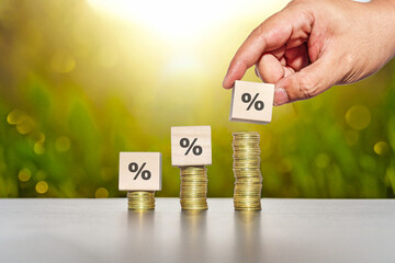 Hand picked percentage sign on wooden cubes. Stacking for interest rate and business profit growth...