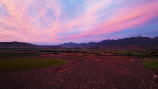 Sunset to twilight over countryside fields and mountains in the high, Utah desert - aerial hyper lapse